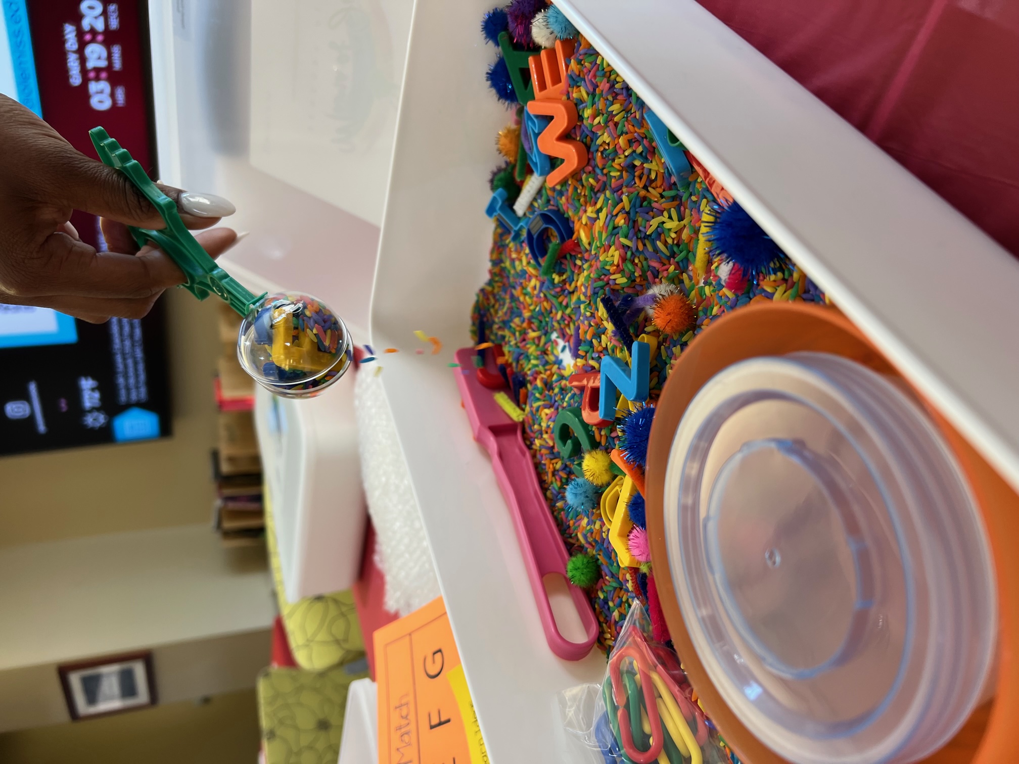 a sensory box with colorful rice and letters