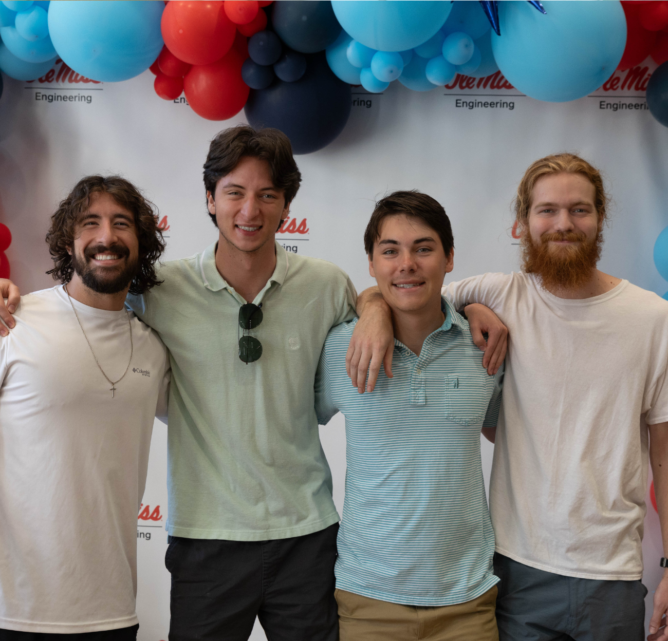 A group of 4 students pose and smile on their first day of the semester