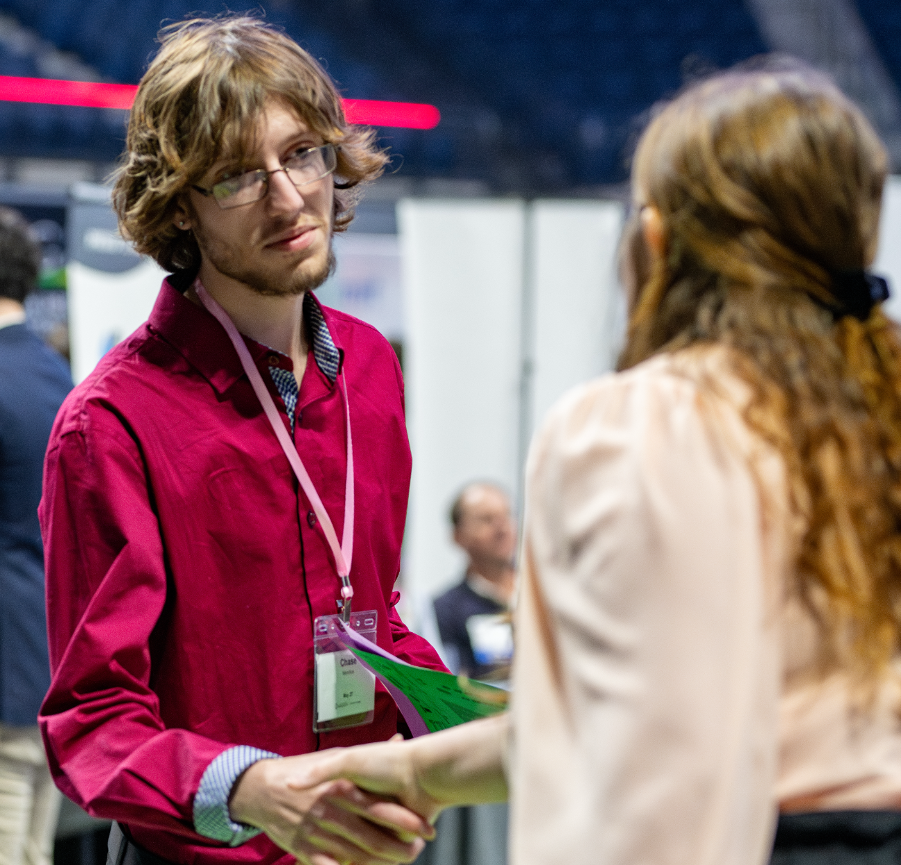 A student shakes hands with an employer at a career fair