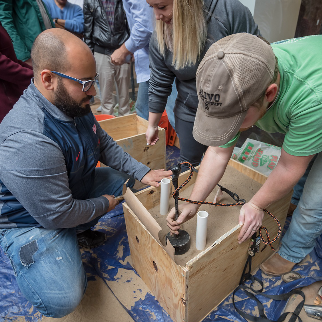 A student and instructor work together on a box structure in a civil engineering class