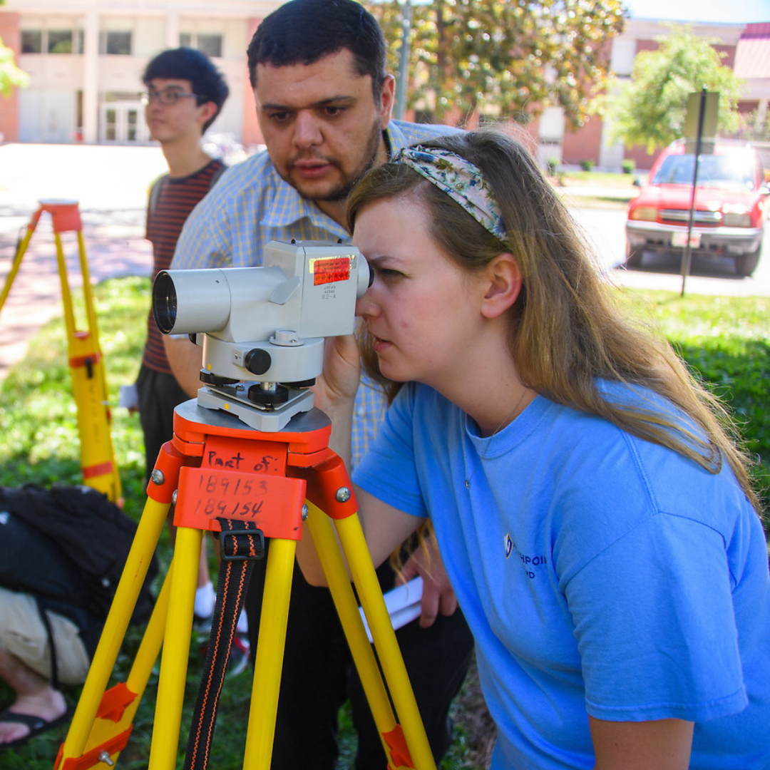 A student and her professor use surveying tools in a survey class