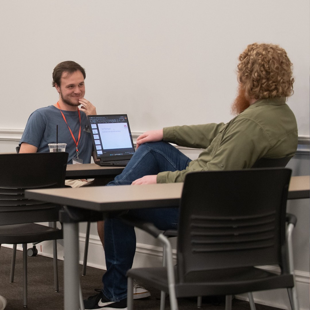 Instructor provides guidance to a student during a hackathon
