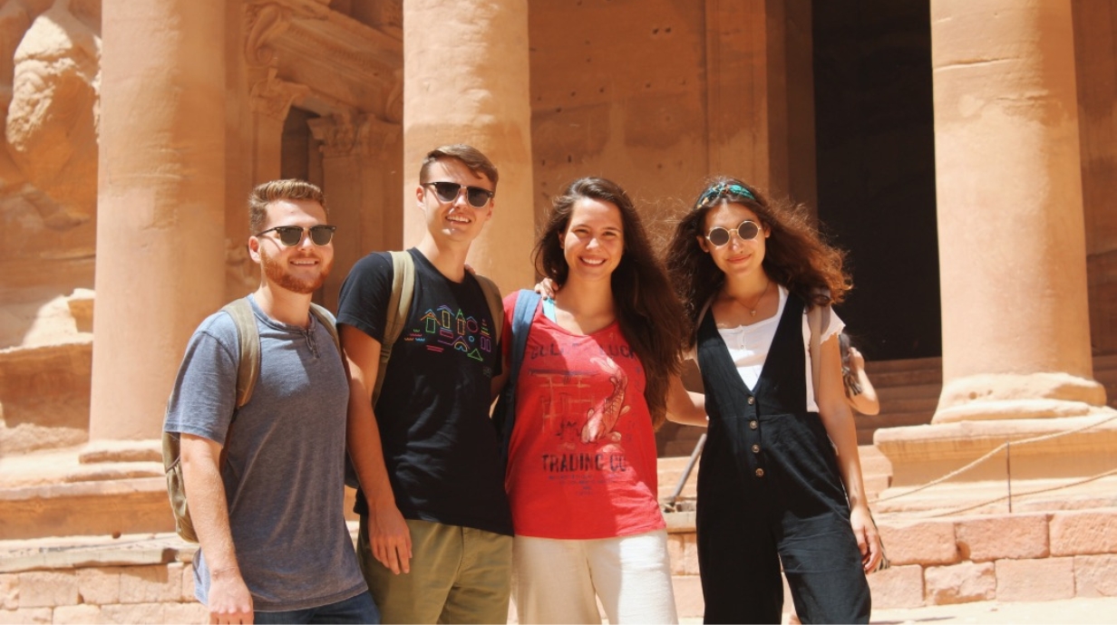 Four students standing in front of ancient ruins