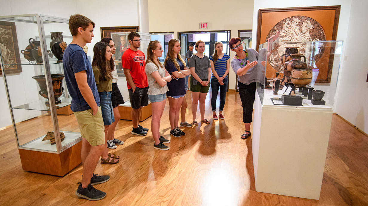 Molly Pasco-Pranger discusses ancient art while a group of students looks on. 
