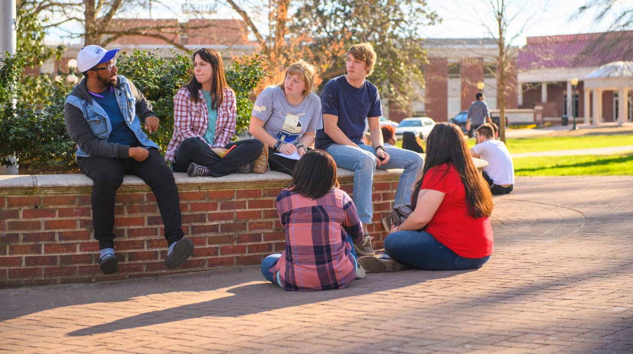 Diverse group of students talk outside of class. 