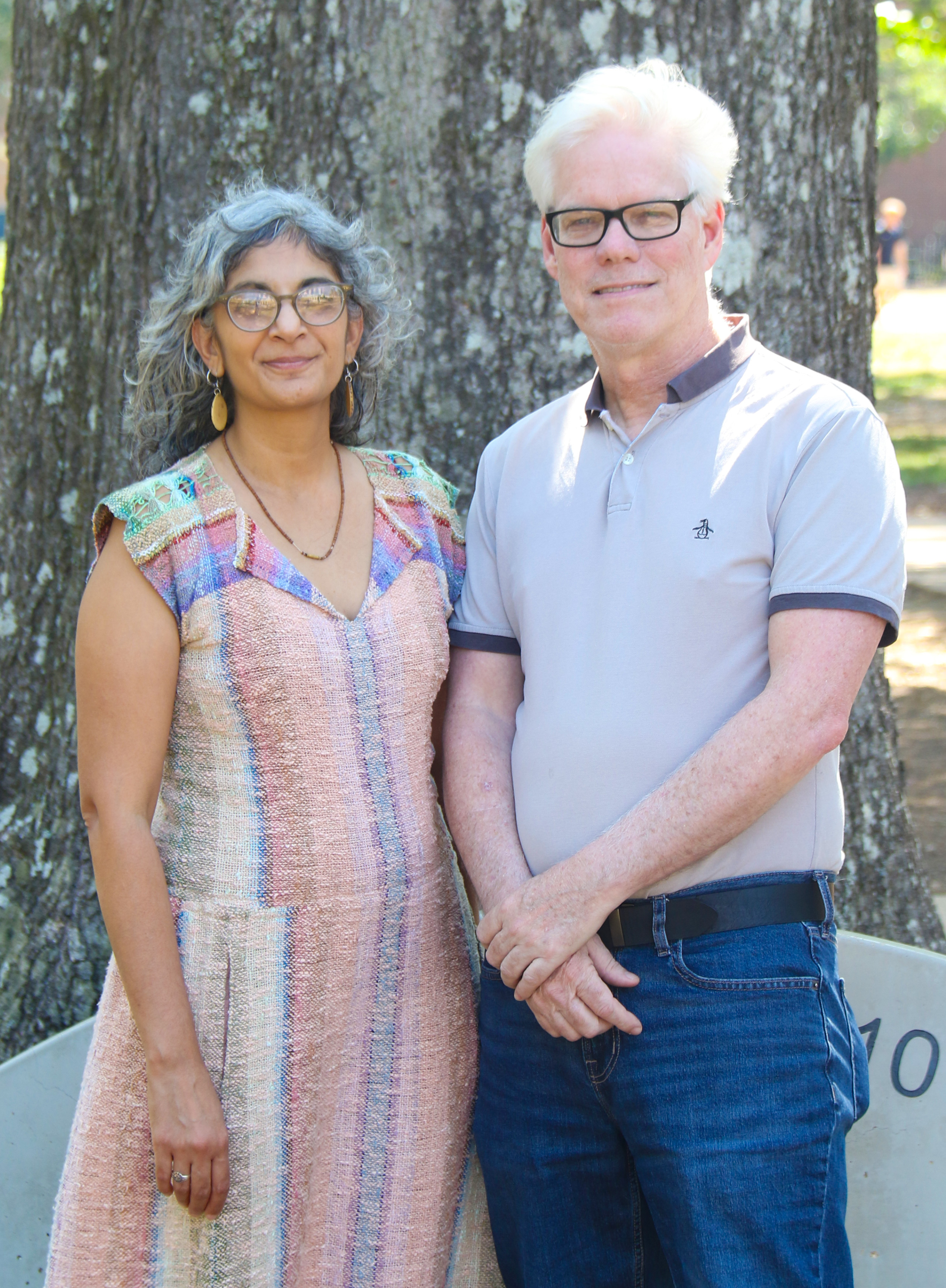 Dr. Stephen Brewer and Dr. Shaila Wadhwani-Greenhalgh standing outside in the Grove