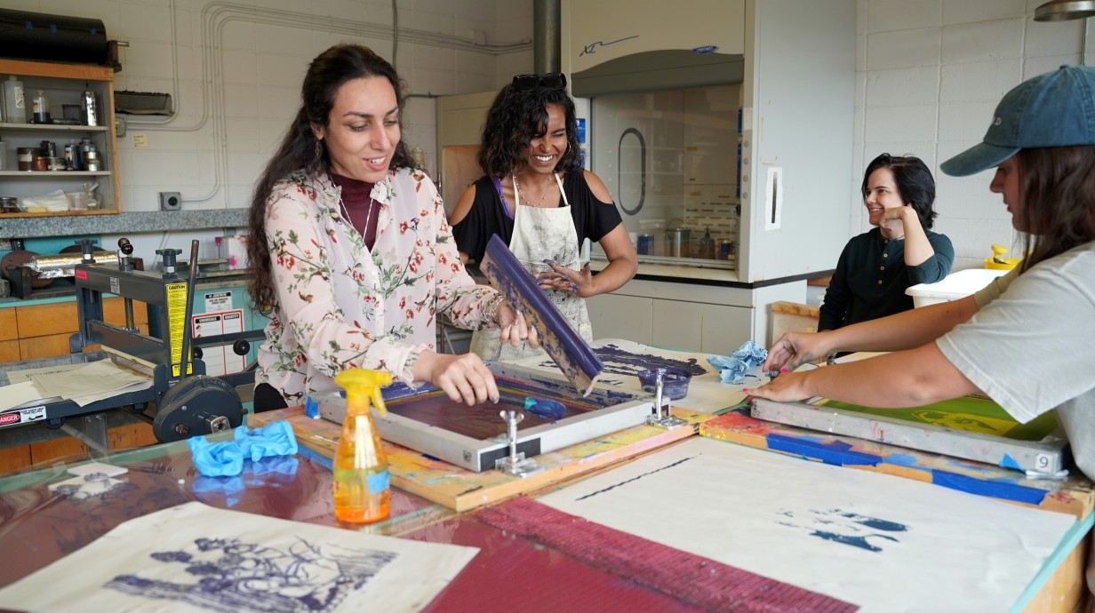 Students working at the press in the printmaking studio