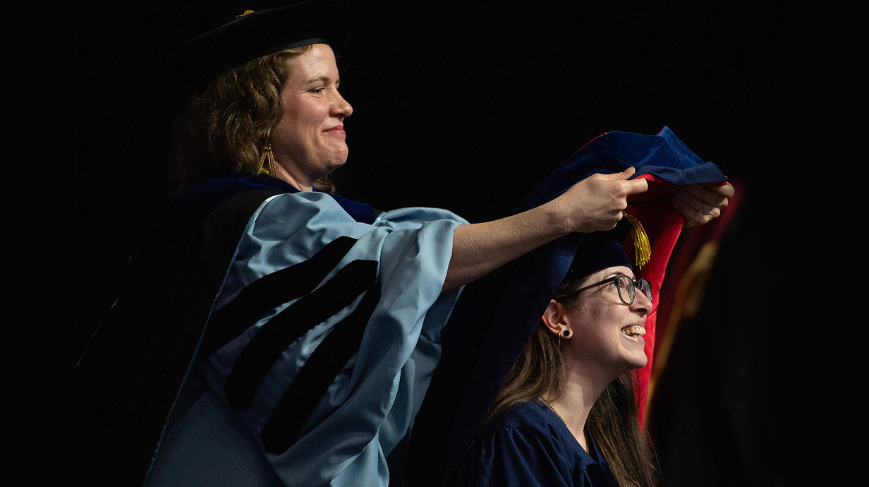 Professor and Ph.D. candidate at a hooding  ceremony.