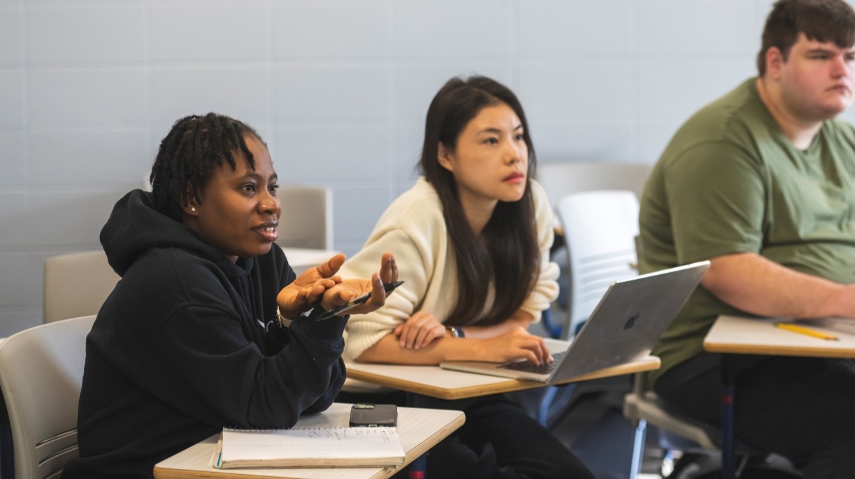 image of students sitting in a classroom talking
