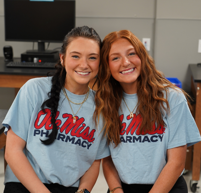 two students smiling at the camera