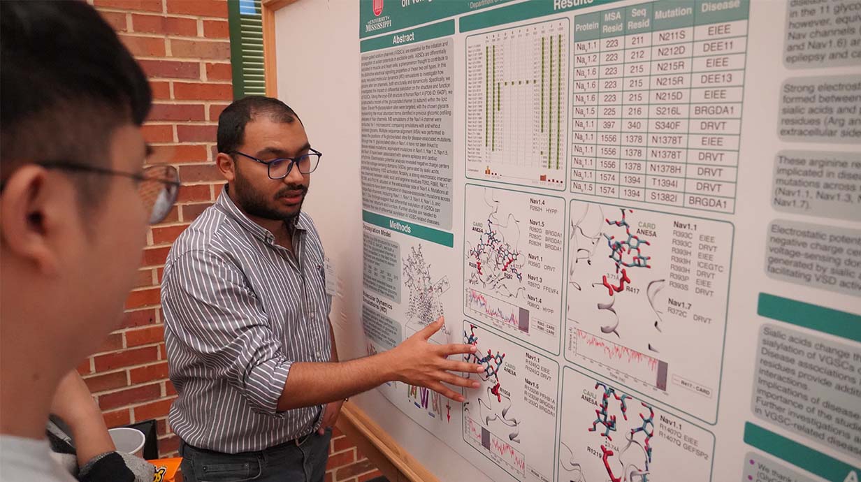 PhD Student showing poster during conference.