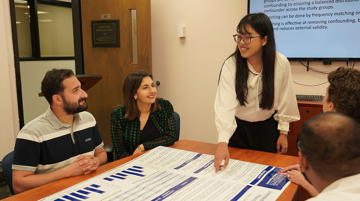 Photo of pharmacy administration students discussing their research.