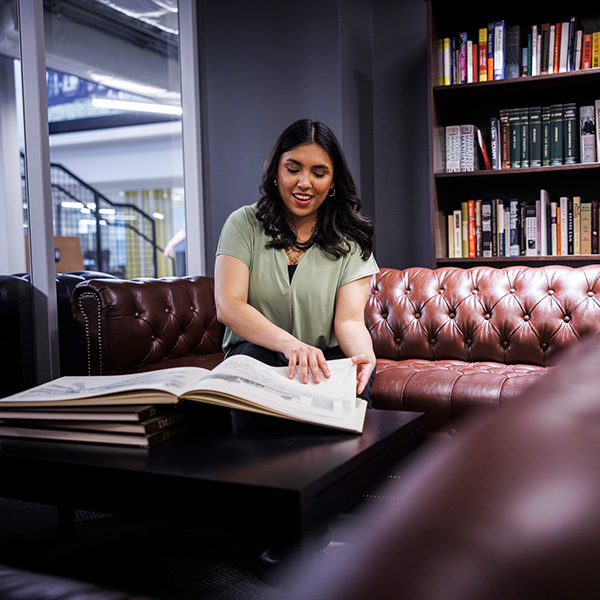 A pre-law student turns a page in a reference book in the library.