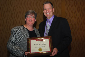 NACADA president Jennifer Joslin presents a certificate of merit to David McCaffrey.
