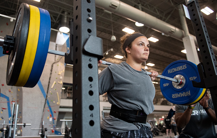 An Ole Miss student, standing inside a squat rack, lifts weights at the South Campus Recreation Center.