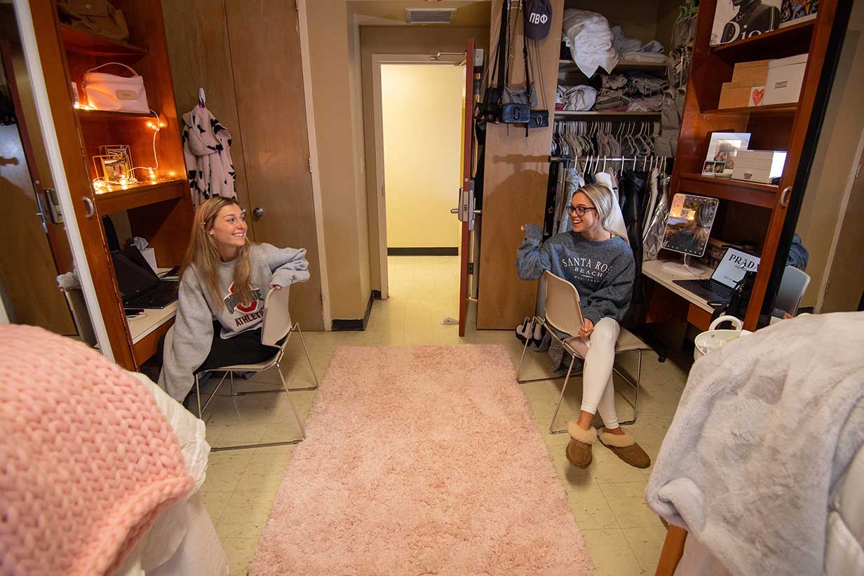 Two new roommates sit at their desks in their new dorm room in Crosby Hall.