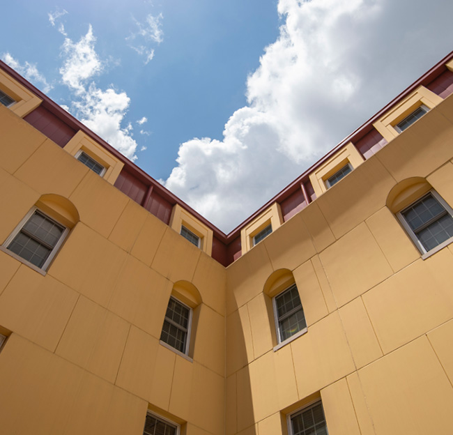 A photo of the Luckyday Residential College courtyard looking up the walls toward the sky.