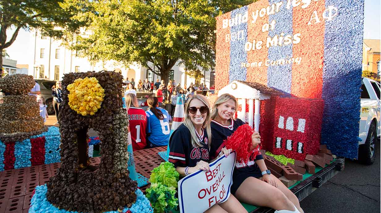 Members of Alpha Phi sorority ride their homecoming float through the Oxford Square during the annual Homecoming Parade.