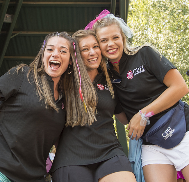 3 CPH recruitment counselors pose on stage in the Grove during Panhellenic sorority recruitment