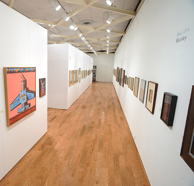 A university museum gallery depicting the paintings of Glen Ray Tutor.