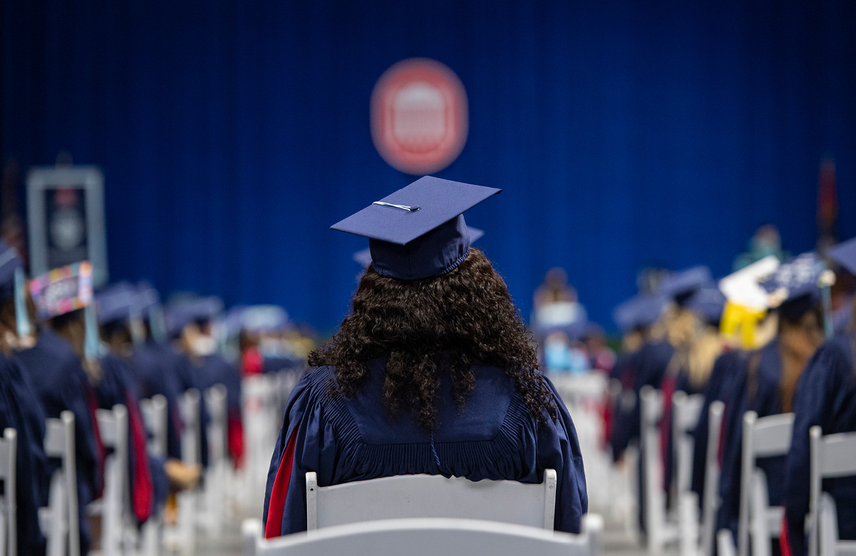 The Lyceum logo is blurred above a UM graduate’s cap during the School of Education Commencement Ceremony at The Pavilion.